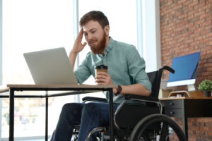 An injured victim in a wheelchair has a video call with a Long Beach catastrophic injury lawyer.
