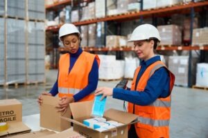 Two female warehouse employees scan packages while discussing five California employment laws every worker should know.