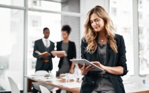 Business woman, tablet and online in office for research, networking and communication with news.